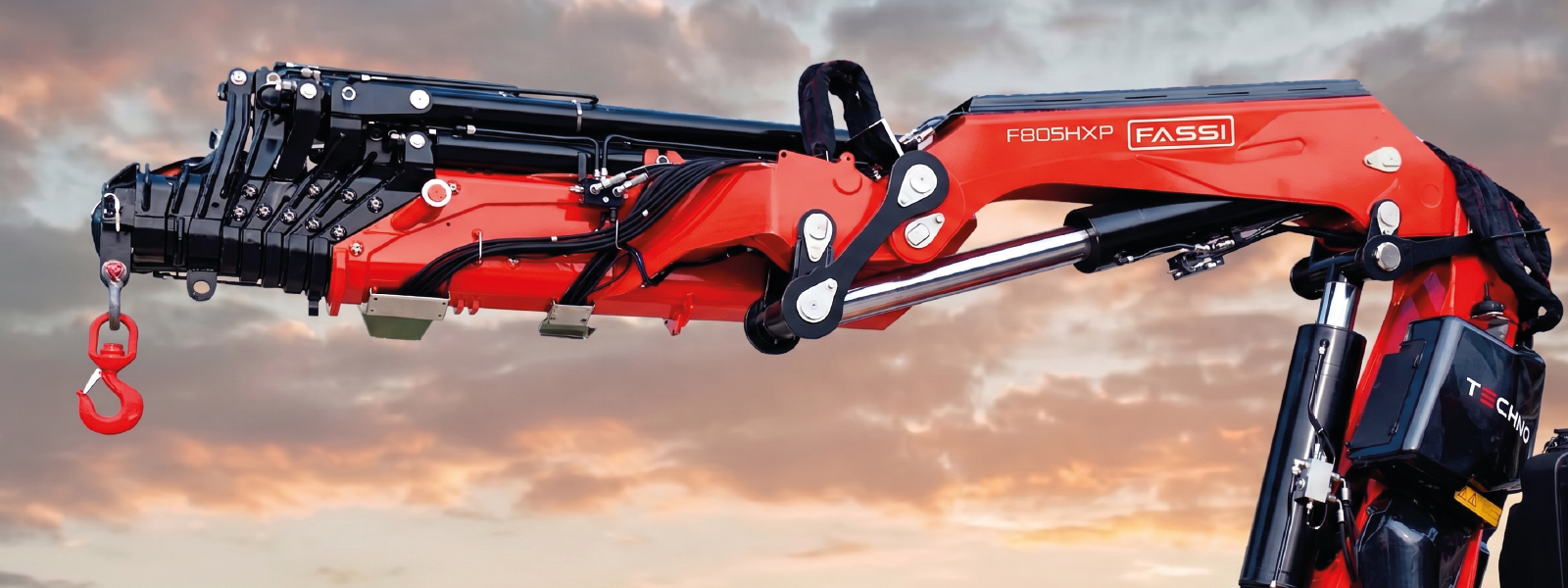 Primer plano de una de las grúas Fassi modelo F805R.2.8 mostrando su brazo articulado y gancho rojo. 