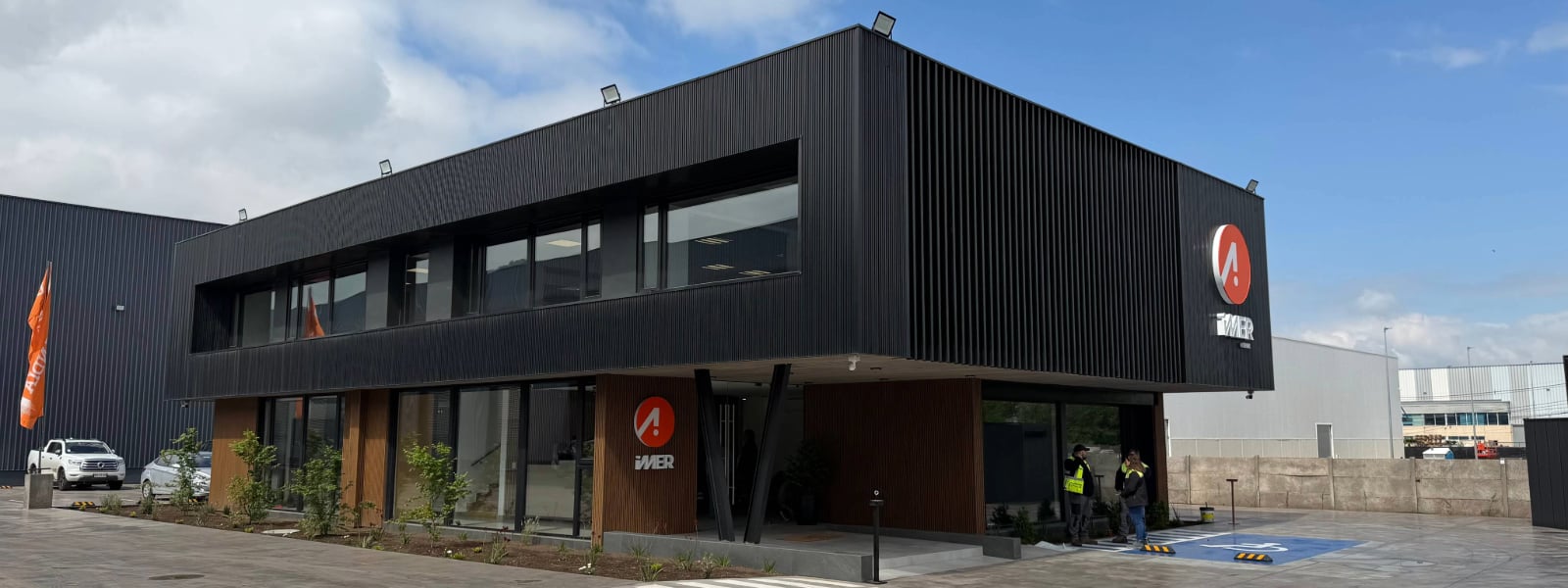Edificio corporativo moderno de la nueva casa matriz IMER Chile con fachada negra y acabados de madera.